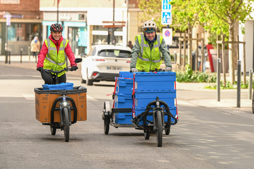 deux cyclologisticiens ( charlotte et maxime ) souriant de face lors de la collecte de biodechets dans les rues de Dunkerque