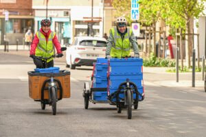 deux cyclologisticiens ( charlotte et maxime ) souriant de face lors de la collecte de biodechets dans les rues de Dunkerque